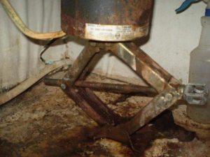 Garbage disposal held up with a car jack